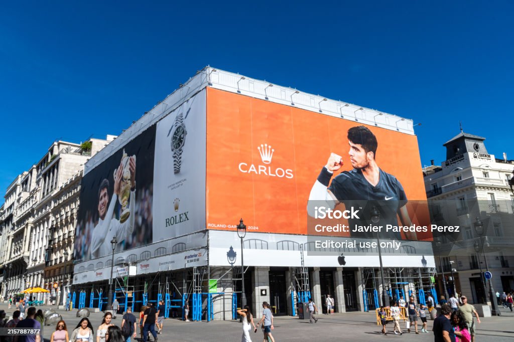 Madrid, Spain. June 16, 2024. Rolex advertising canvas at the Puerta de Sol, with photos of Carlos Alcazar with the champion cup celebrating the Wimbeldon and Roland Garros tennis grad slam titles.